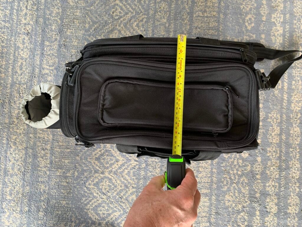 A top down view of the Aerocoast Pro Crew I flight bag with an open tape measure showing the width of the bag.