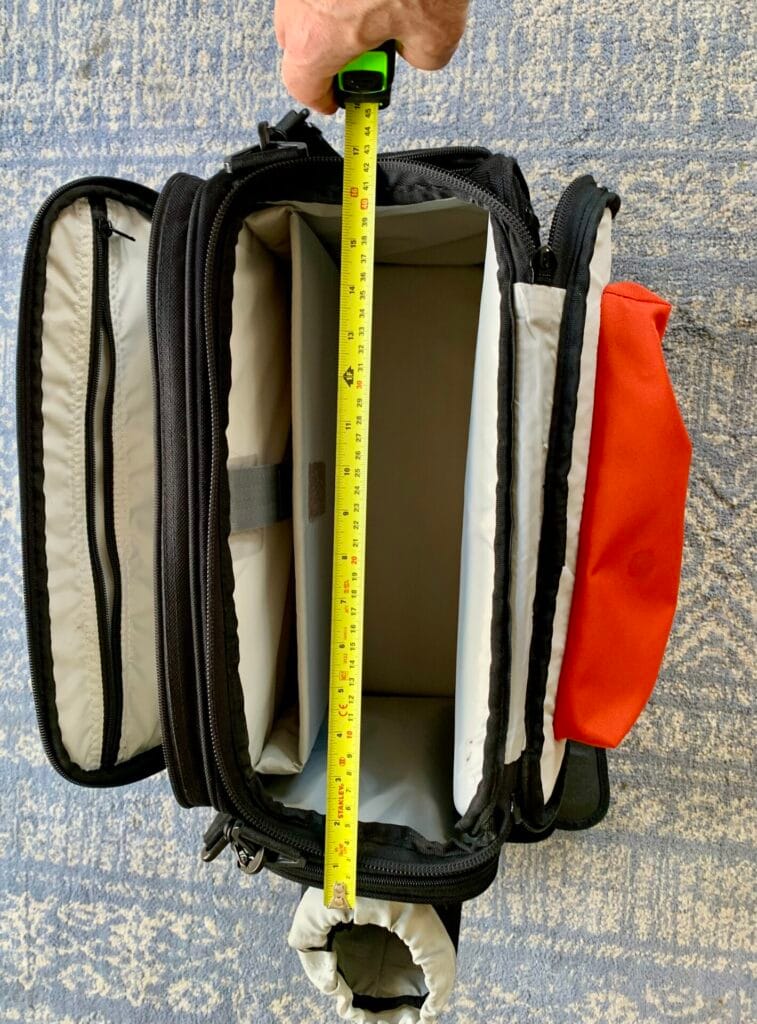 A top down view of the Aerocoast Pro Crew I flight bag with an open tape measure showing the length of the bag. The bag is open showing the inside of the various pockets.